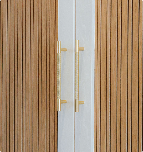 Close-up of bespoke wooden wardrobe door handles and natural wood grain textures.